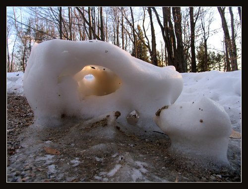 Snow hole, illuminated by winter sunset