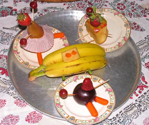 Three Fruit People sitting at a Banana Table